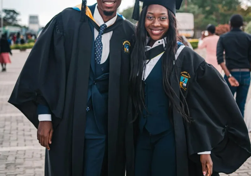 Des jeunes diplômés en toge posent ensemble, sourire aux lèvres, après leur réussite